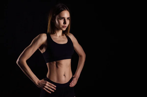 Mulher musculosa desportiva fazendo exercícios com halteres isolados em fundo preto. Atlético jovem mulher fazer um treino de fitness com pesos . — Fotografia de Stock