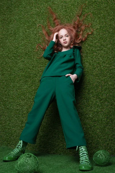 Fashion studio porträtt av söt liten rödhårig flicka bär gröna kläder. — Stockfoto
