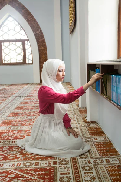 Girl with hijab reading koran and praying