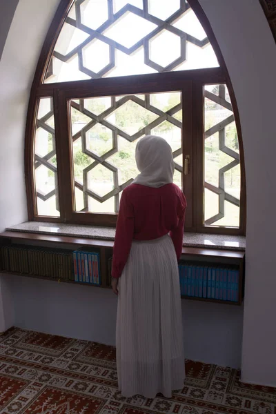 Girl with hijab reading koran and praying