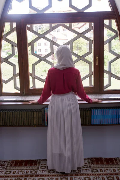 Girl with hijab reading koran and praying