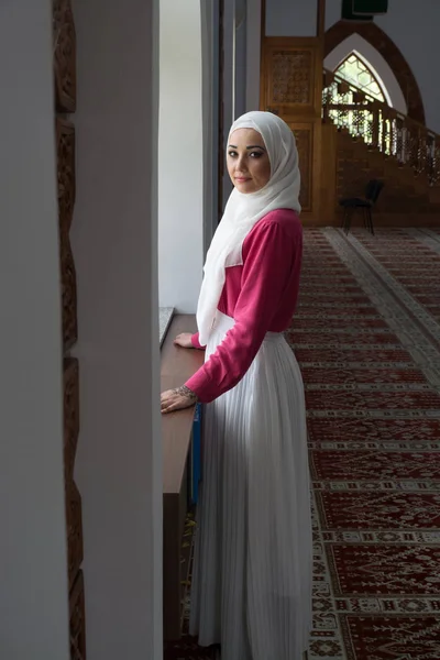Girl with hijab reading koran and praying