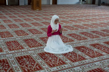 Müslüman kadın camide namaz kılıyor.