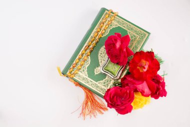 Kuran'ı tespih ve beyaz arka plan üzerinde izole çiçeklerle