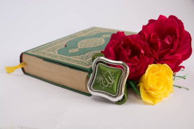 Kuran'ı tespih ve beyaz arka plan üzerinde izole çiçeklerle