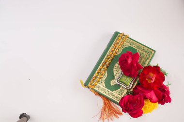 Kuran'ı tespih ve beyaz arka plan üzerinde izole çiçeklerle