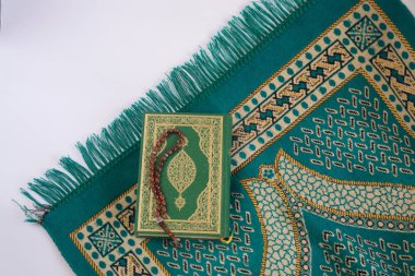 Kuran'ı tespih ve beyaz arka plan üzerinde izole çiçeklerle