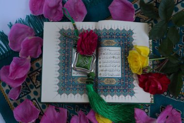 Kuran'ı tespih ve beyaz arka plan üzerinde izole çiçeklerle