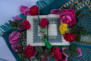 Kuran'ı tespih ve beyaz arka plan üzerinde izole çiçeklerle