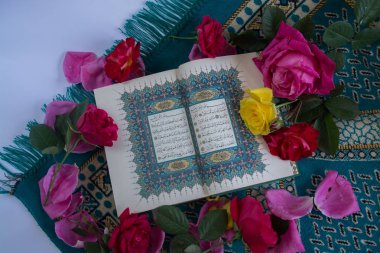 Kuran'ı tespih ve beyaz arka plan üzerinde izole çiçeklerle