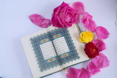 Kuran'ı tespih ve beyaz arka plan üzerinde izole çiçeklerle