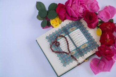 Kuran'ı tespih ve beyaz arka plan üzerinde izole çiçeklerle