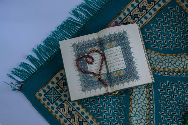 Kuran'ı tespih ve beyaz arka plan üzerinde izole çiçeklerle