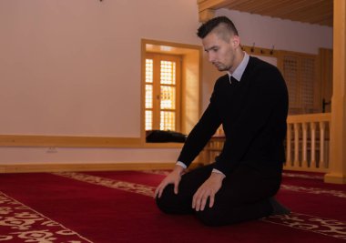 Genç Müslüman adam dua ediyor.