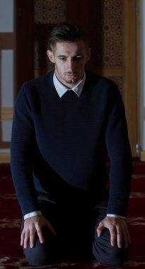 Genç Müslüman adam dua ediyor.