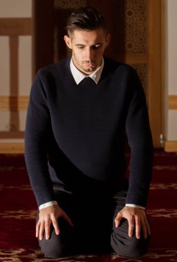 Genç Müslüman adam dua ediyor.