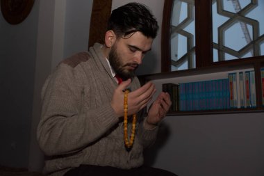 Genç Müslüman adam dua ediyor.