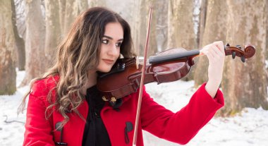 Güzel kız oyun ve bir violine ile poz