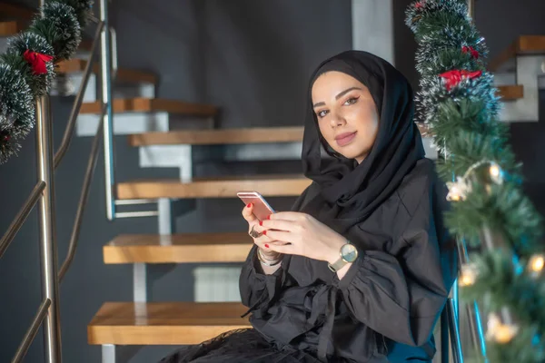 Dizüstü bilgisayarda yazı yazan, telefonla konuşan ve fotoğrafçılığı öğrenen güzel kız.