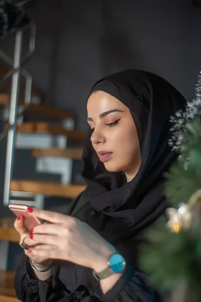 Dizüstü bilgisayarda yazı yazan, telefonla konuşan ve fotoğrafçılığı öğrenen güzel kız.