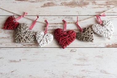 Ahşap bir arka planda asılı renkli ahşap kalpler..