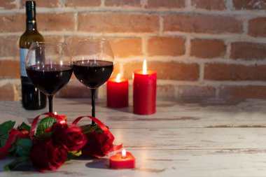 Kırmızı renklerde romantik bir akşam şarap, güller ve mumlarla.