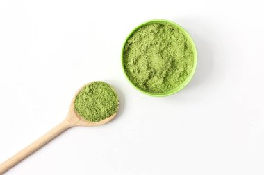 Tahta kaşık ve toz kibrit yeşil çay beyaz arka planda izole edilmiş..