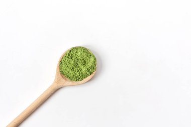 Tahta kaşık ve toz kibrit yeşil çay beyaz arka planda izole edilmiş..
