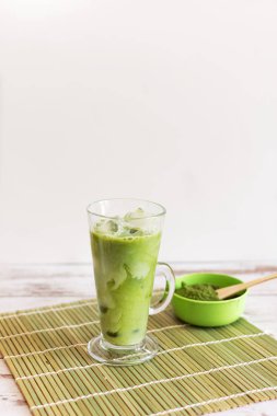 Meyve suyu bardağında buzlu kibrit latte. Hindistan cevizi sütüyle birlikte sürahiden elle dökülüyor. Boşluğu kopyala..