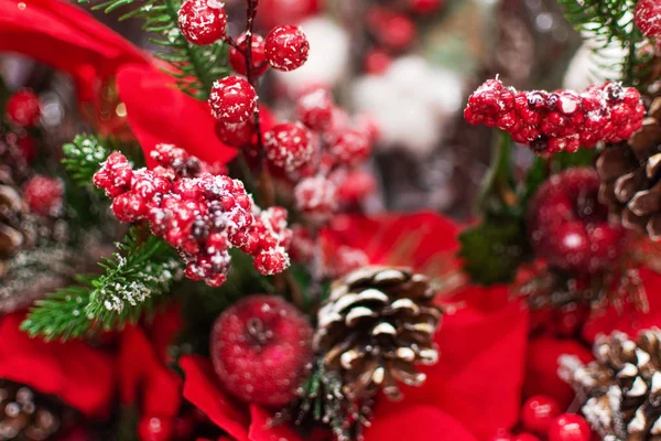 Fake plant of pine needles, pine cone and red berries for Christmas home decoration.