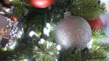 Noel ağacı süslemesi. Kırmızı ve gümüş toplar ve ışıklı çelenkler. Bokeh 'le yeni yıl fotoğrafı. Kış tatili hafif dekorasyonu.