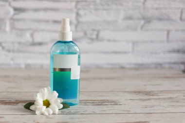 Papatya çiçekli doğal bitkisel cilt bakımı toniği. Ahşap arka planda yüz tazeleyici tonik.