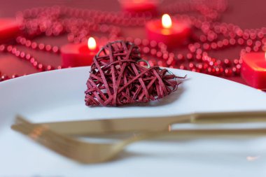 Sevgililer Günü için çatal, bıçak, peçete ve kalp süsleme masası. Sevgililer Günü 'nde akşam yemeği..