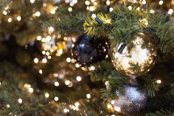 Украшенная елка крупным планом. Золотые, черные и серебряные шарики и гирлянда с огнями. Новогоднее фото с боке. Зимние праздники . — стоковое фото
