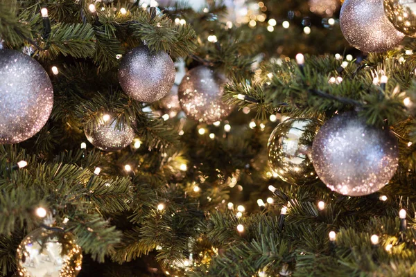 Zdobené vánoční stromeček detailní záběr. Zlaté, černé a stříbrné koule a věnce se světly. Novoroční fotka s Bokeh. Zimní dovolená světlo dekorace. — Stock fotografie