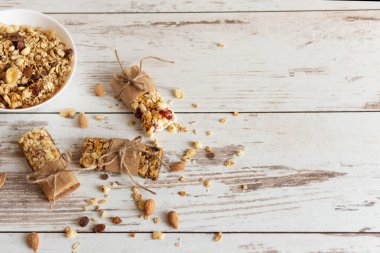 Tahta masa arkasında fındıklı, meyveli ve meyveli tahıl gevreği barı. Sağlıklı tatlı atıştırmalığı.