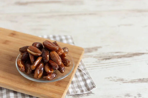 Bowl of dried dates on wooden background with space for text. — Stock Photo, Image