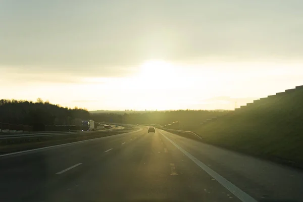 Nascer do sol na estrada a partir da janela do carro . — Fotografia de Stock