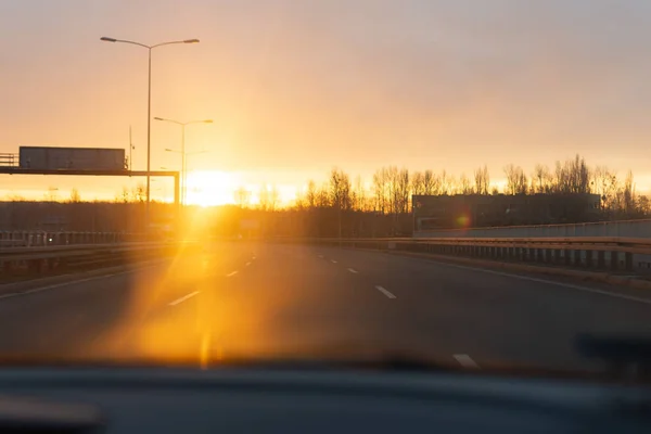 Wschód słońca na drodze z okna samochodu. — Zdjęcie stockowe