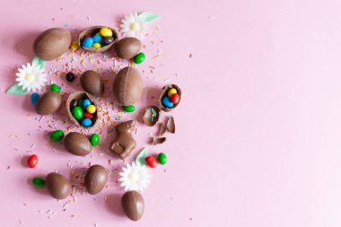 Pastel pembe arka planda çikolatalı Paskalya yumurtaları düz. Boşluğu kopyala.