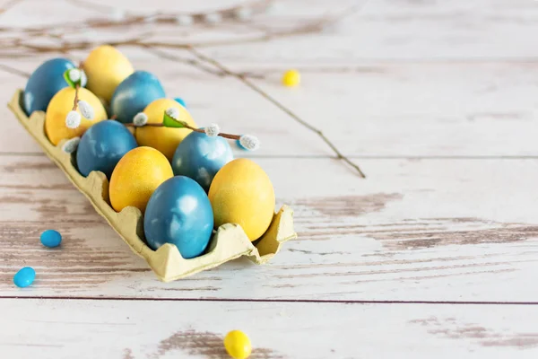 Oeufs de Pâques en marbre bleu et jaune sur table en bois . — Photo