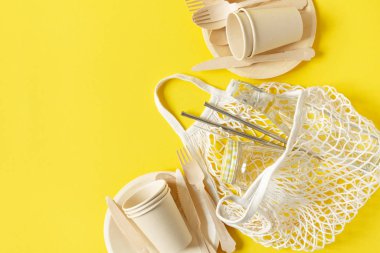 Tek kullanımlık sofra takımlarıyla alışveriş yapmak için pamuk örgü çanta. Sıfır atık, plastiksiz, sürdürülebilir yaşam tarzı konsepti.