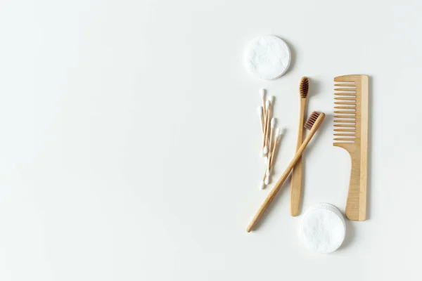 Две биоразлагаемые, компостируемые бамбуковые зубные щетки, расческа для волос и хлопчатобумажные подушки на белом фоне . — стоковое фото