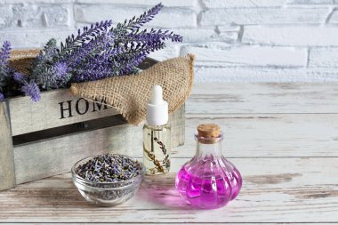 Ahşap masa arkasında bir demet lavanta çiçeği, kurutulmuş lavanta ve aromatik lavanta yağı. Spa ya da alternatif tıp konsepti. Boşluğu kopyala.