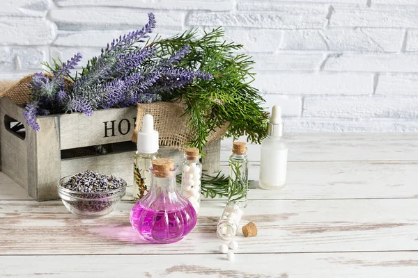 Bunch of lavender flowers, dried lavender and aromatic lavender oil on wooden table background. Spa or alternative medicine concept. Copy space.