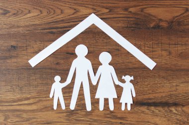 Koyu ahşap arka plan manzaralı güzel bir kağıt aile. Mutlu aile, sigorta konsepti.