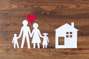 Koyu ahşap arka plan manzaralı güzel bir kağıt aile. Mutlu aile, sigorta konsepti.