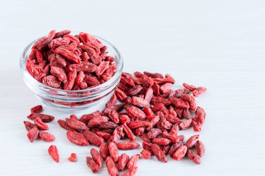 Beyaz arka planda bir kase kurutulmuş kurt üzümü. Süper yiyecekler. Sağlıklı yeme kavramı.