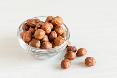 Beyaz ahşap arka planda cam kasede soyulmuş fındıklar. Sağlıklı beslenme konsepti. Süper Yiyecekler.