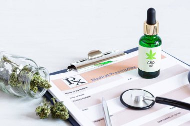 Bir şişe Cbd yağı, kenevir tohumu ve kuru yapraklar beyaz ahşap masadaki tıbbi reçete kağıdının üstünde. Tıbbi marihuana, alternatif tıp konsepti.